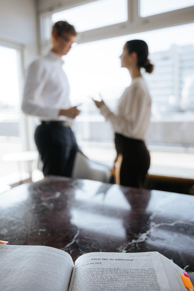 Zwei Mitarbeiter in einer Anwaltskanzlei, welche am diskutieren sind